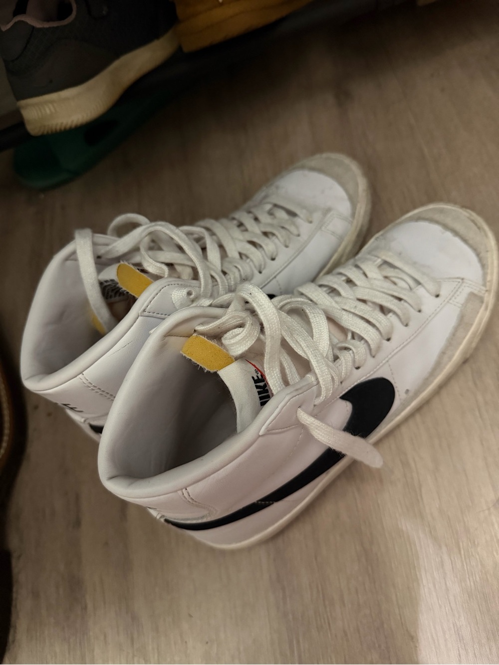 Nike White High-Top Sneakers with Black Swoosh and Yellow Tongue Tab